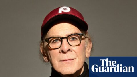 Portrait of Art Garfunkel in black jumper and baseball cap