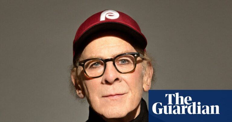 Portrait of Art Garfunkel in black jumper and baseball cap