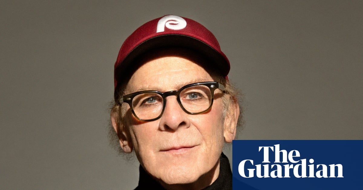 Portrait of Art Garfunkel in black jumper and baseball cap