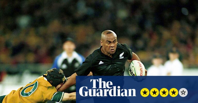 Jonah Lomu carries the ball while evading a tackle attempt from an Australian opponent