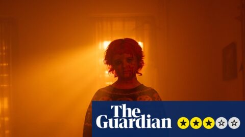 In Hallowarrior, a blood-spattered figure in a pumpkin jumper stands in a smoky, orange-lit room