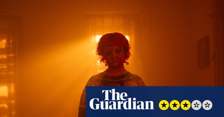 In Hallowarrior, a blood-spattered figure in a pumpkin jumper stands in a smoky, orange-lit room